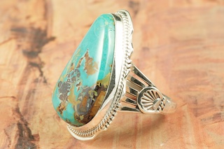 Genuine Sunnyside Turquoise set in Sterling Silver Ring. The matrix on this rare stone is outstanding. The Sunnyside mine is located in northern Nevada near the town of Tuscarora in the Tuscarora mountain range. The mine is no longer in operation as it has become part of a gold mining operation and a privately owned ranch. The Sunnyside mine was mined mostly in the 70's. You won't find much of this great turquoise around anymore except for old stashes. Created by Navajo Artist Larson Lee. Signed by the artist.